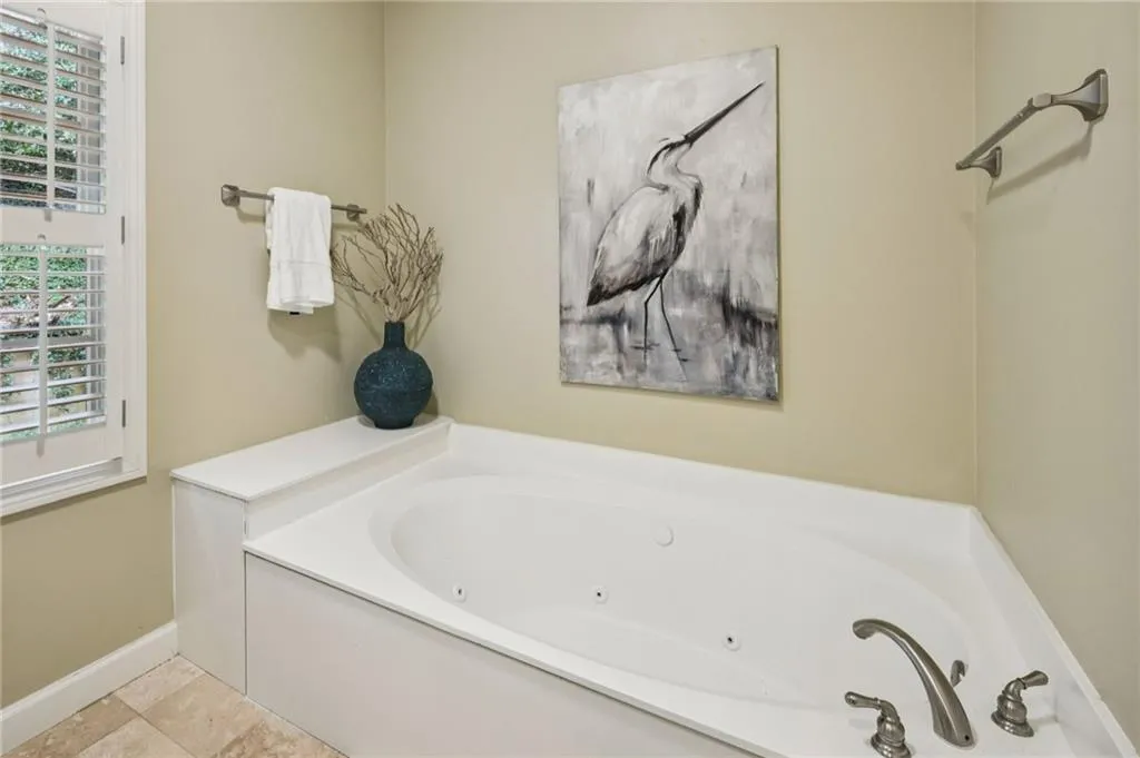 Full bathroom with a whirlpool tub and baseboards