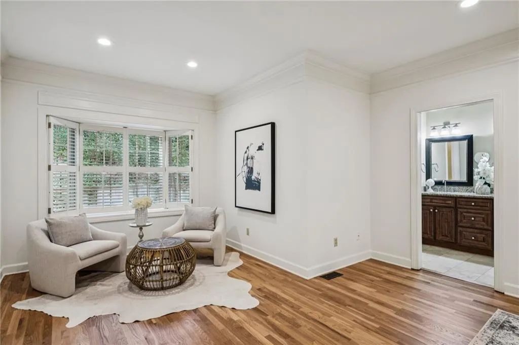 Living area featuring wood finished floors, recessed lighting, and crown molding