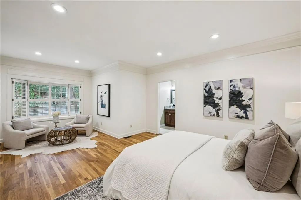 Bedroom with ornamental molding, wood finished floors, recessed lighting, and ensuite bathroom