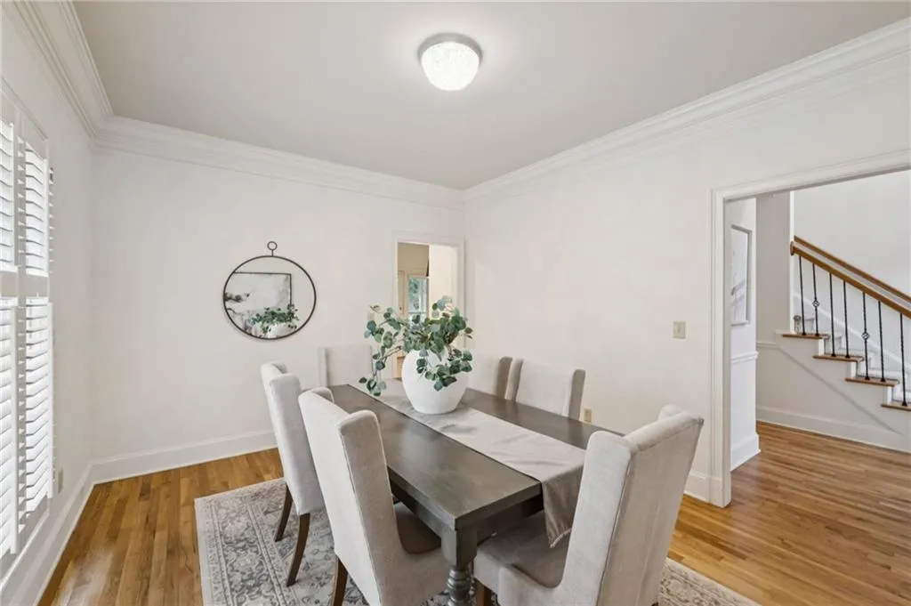Dining room featuring crown molding, light wood finished floors, and stairway