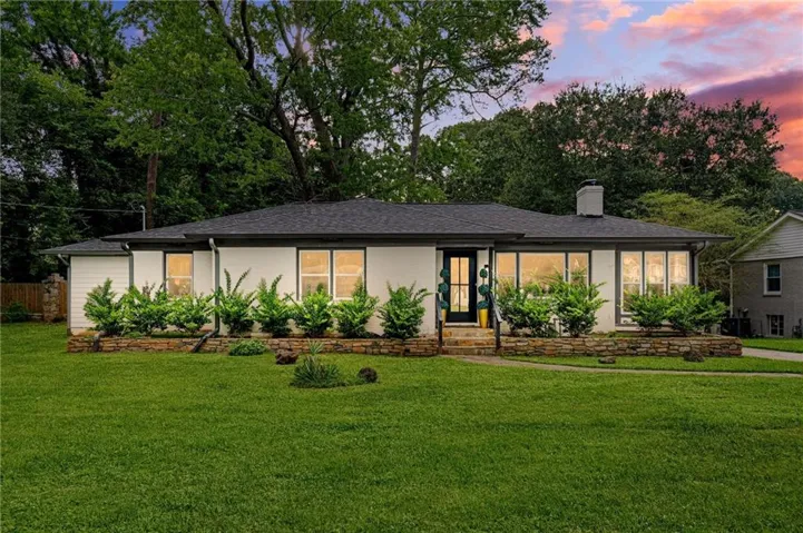 Single-story residence featuring a dark shingle roof, white exterior, and black-trimmed windows