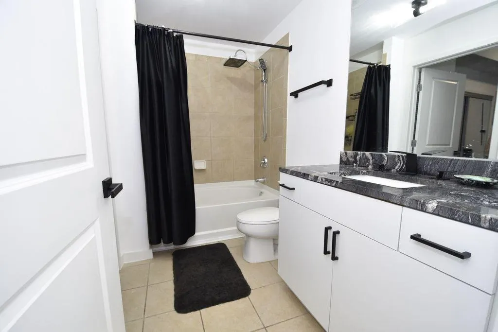 Bathroom with upgraded showerhead, wand, cabinets, hardware, faucet, sink, lighting, fixtures and granite.