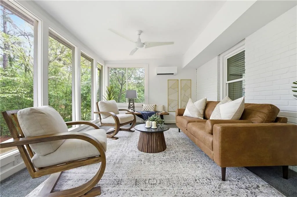 Bright, window-lined sunroom overlooking the backyard, offering a versatile secondary living area. Surrounded by greenery, this space works well as a lounge, playroom, or quiet retreat.