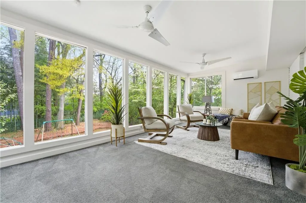 Bright, window-lined sunroom overlooking the backyard, offering a versatile secondary living area. Surrounded by greenery, this space works well as a lounge, playroom, or quiet retreat.