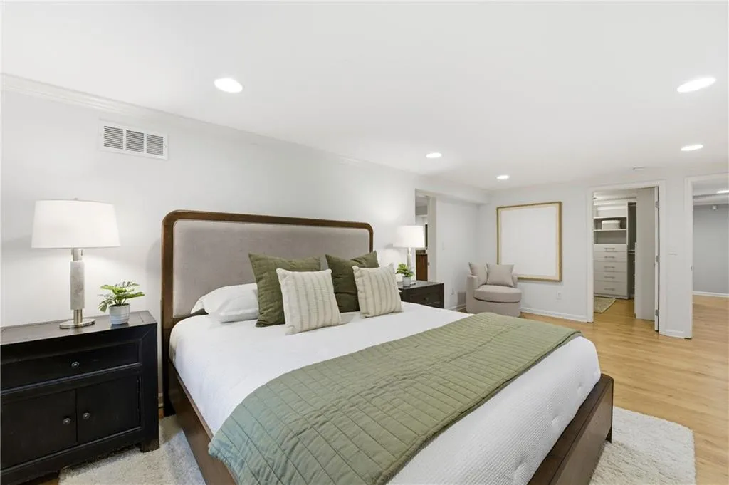Primary BedroomGenerously sized primary bedroom with hardwood floors, recessed lighting, and multiple windows bringing in natural light. Clean lines and a neutral palette create a calm, comfortable retreat.