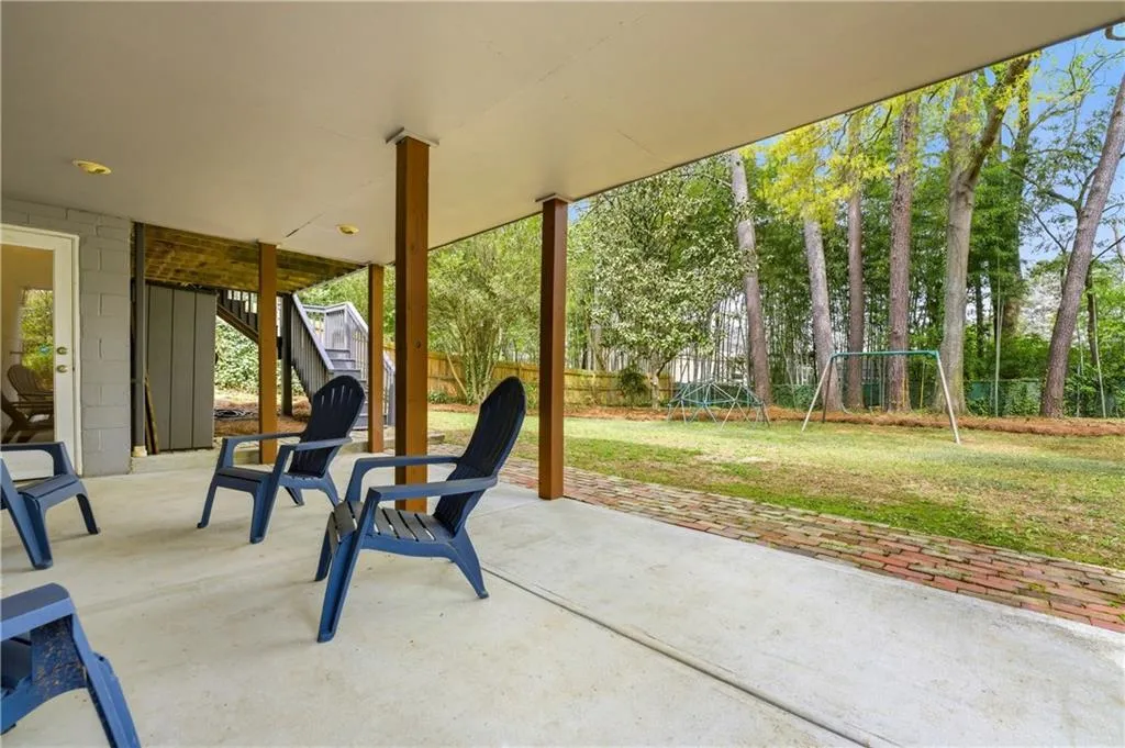 Shaded lower-level patio with direct access to the backyard, connected to a full terrace-level basement with natural light. The large, flat lot makes the outdoor space both practical and easy to enjoy.