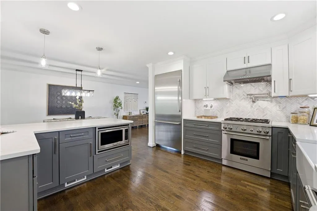 Well-appointed kitchen with ample prep space, quartz countertops, and thoughtful storage. The Thermador appliance suite and built-in refrigerator provide a cohesive, upscale look, complemented by under-cabinet lighting for added visibility and warmth.