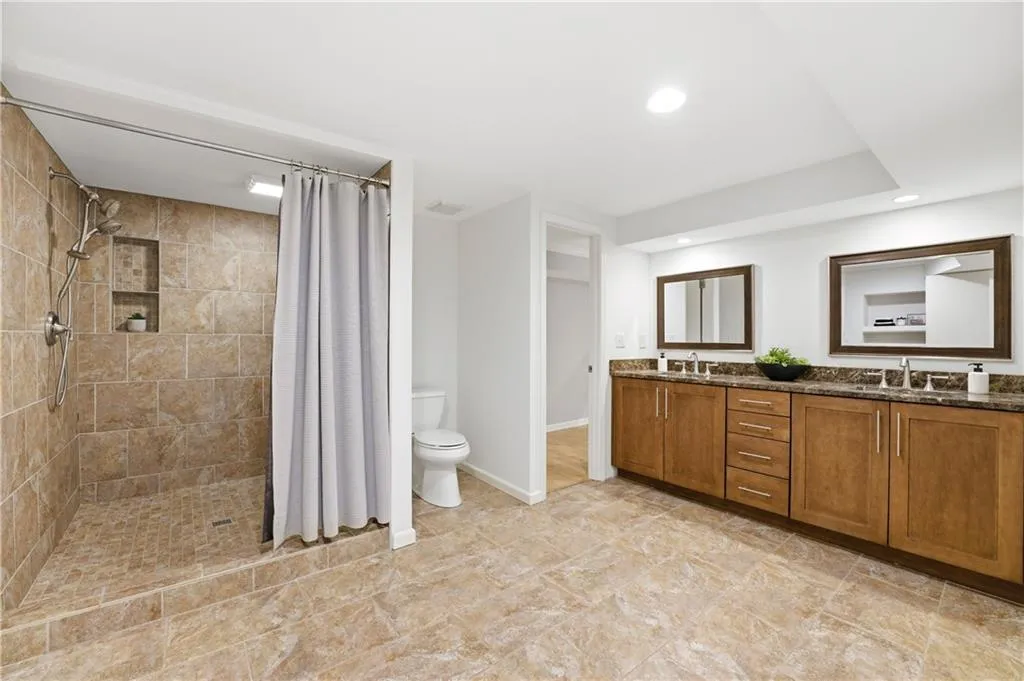 Spacious, updated primary bath featuring an oversized walk-in shower and heated floors for added comfort. Clean finishes and a well-proportioned layout create a functional, spa-like space designed for daily use.