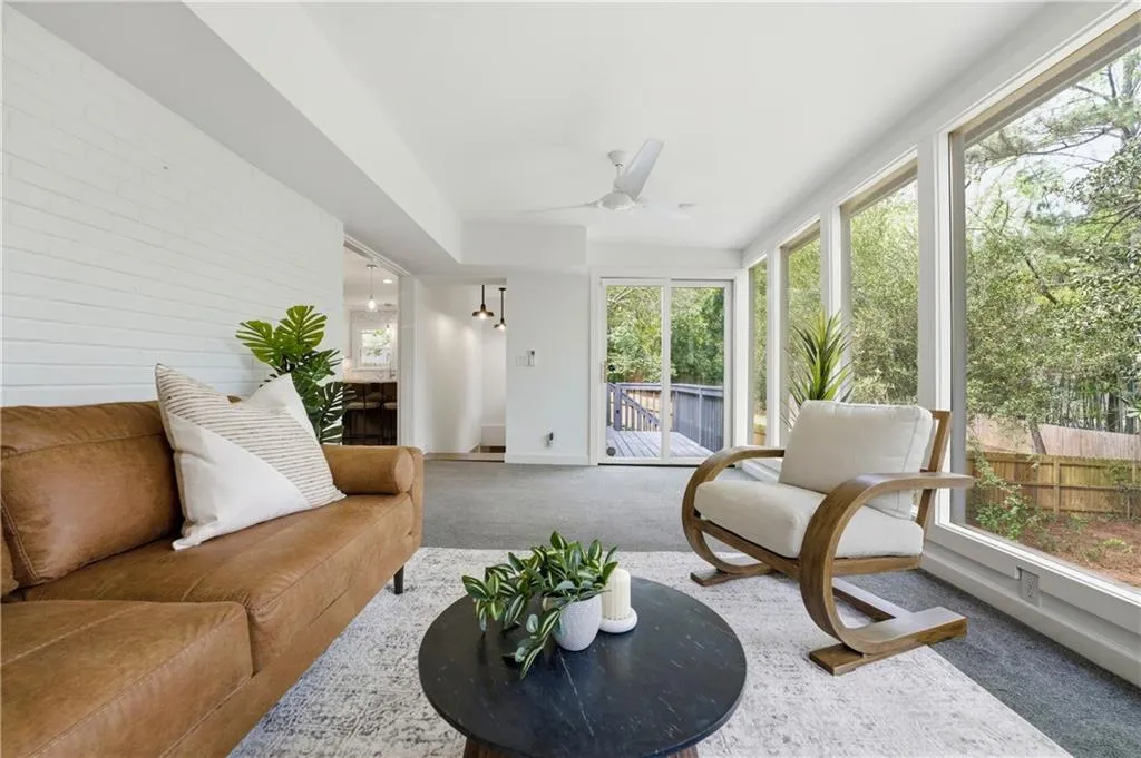 Bright, window-lined sunroom overlooking the backyard, offering a versatile secondary living area. Surrounded by greenery, this space works well as a lounge, playroom, or quiet retreat.
