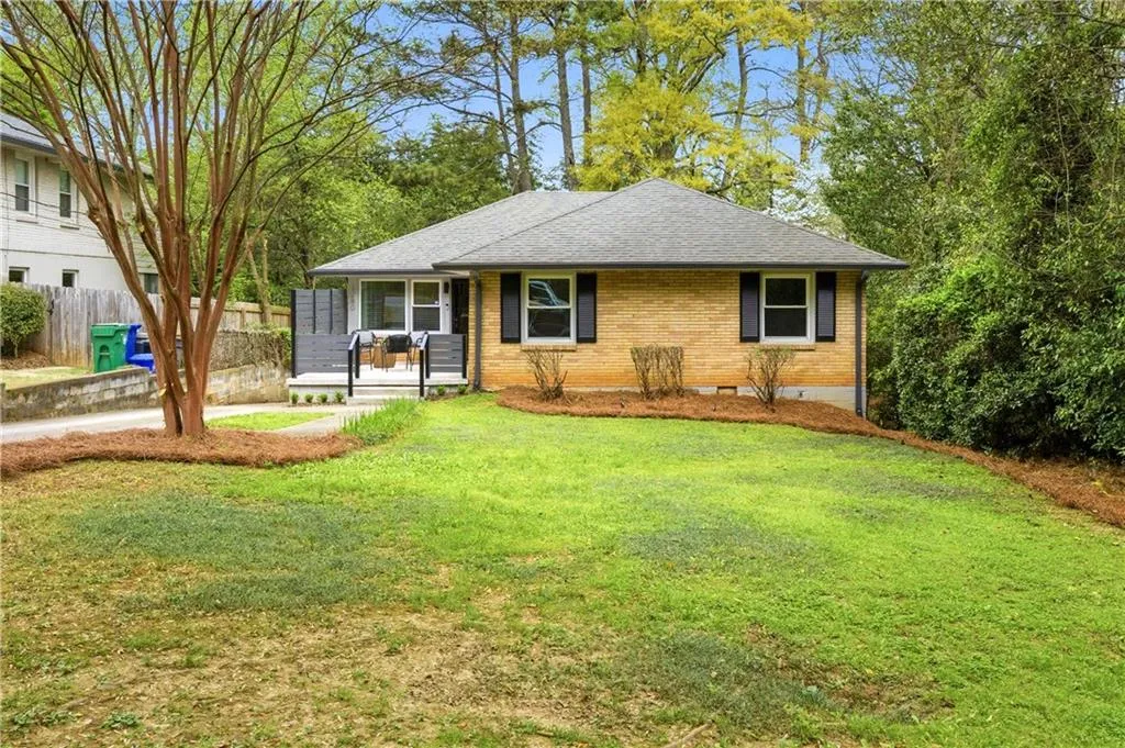 Charming brick ranch set on a gently sloping lot with mature landscaping and a wide front lawn. Clean lines, updated shutters, and fresh mulch beds create strong curb appeal, while the elevated position provides a sense of privacy from the street.