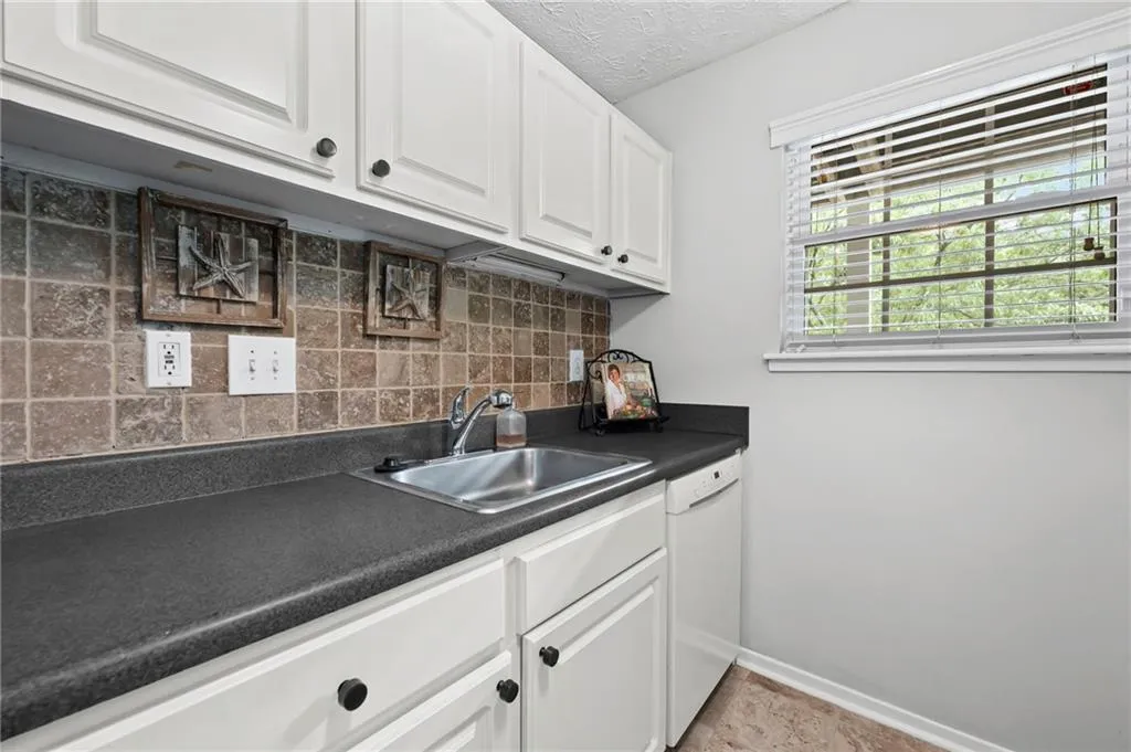Clean kitchen with stainless sink and tile backsplash
