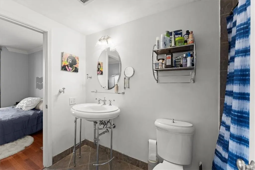 Full bathroom with dark wood-style flooring, connected bathroom, and a shower with shower curtain