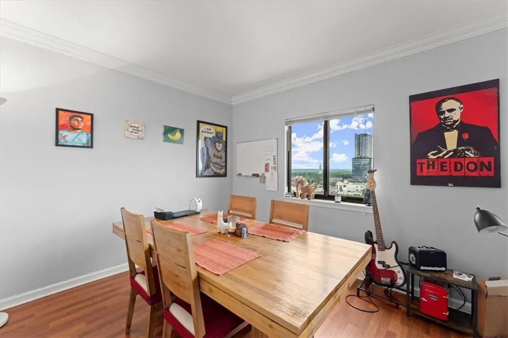Dining space featuring ornamental molding and wood finished floors