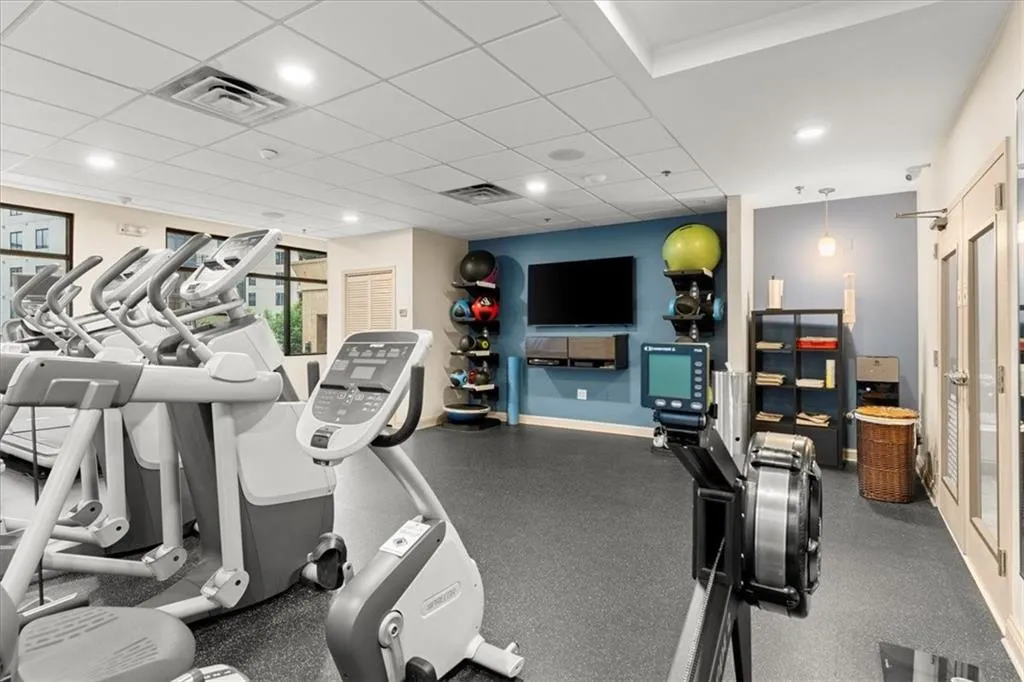 Gym featuring a paneled ceiling and recessed lighting