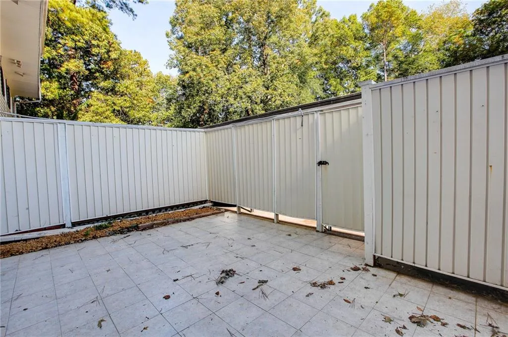 Fenced backyard featuring a patio area and a gate