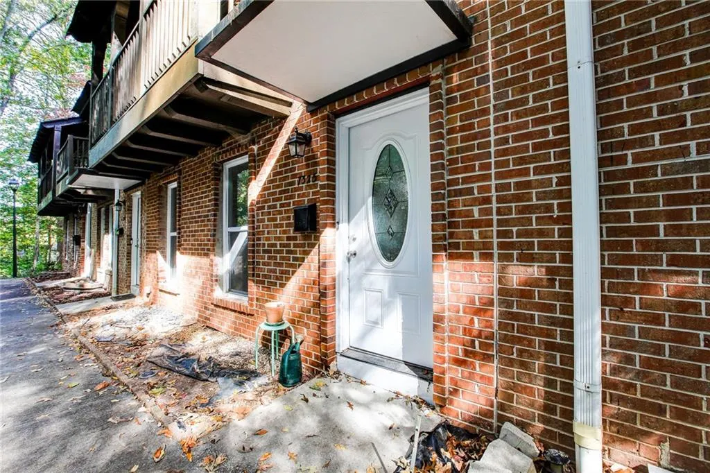 Doorway to property featuring brick siding