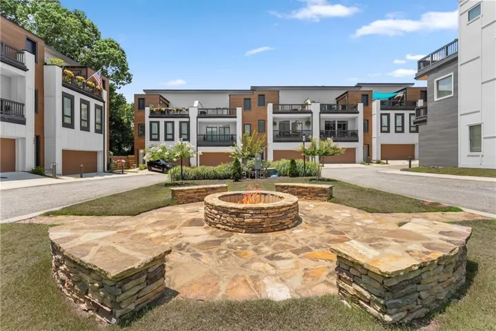 Central flagstone patio featuring a stone-clad fire pit and built-in stone seating