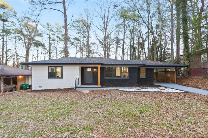 View of front of house with a carport, brick siding, and crawl space