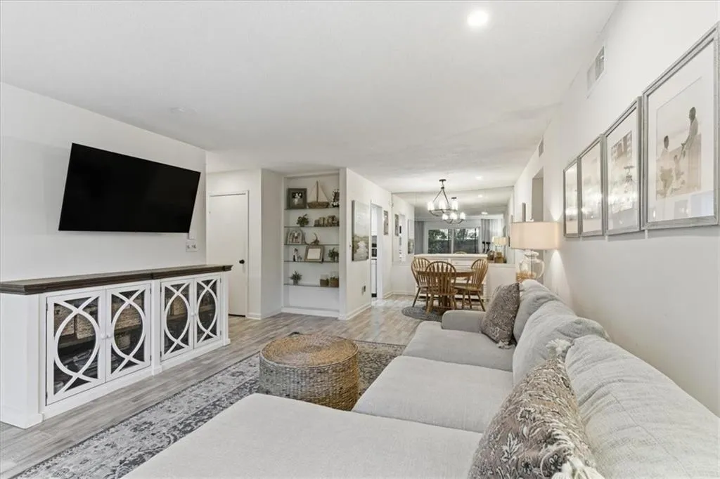 Living room with light wood finished floors, recessed lighting, and a chandelier