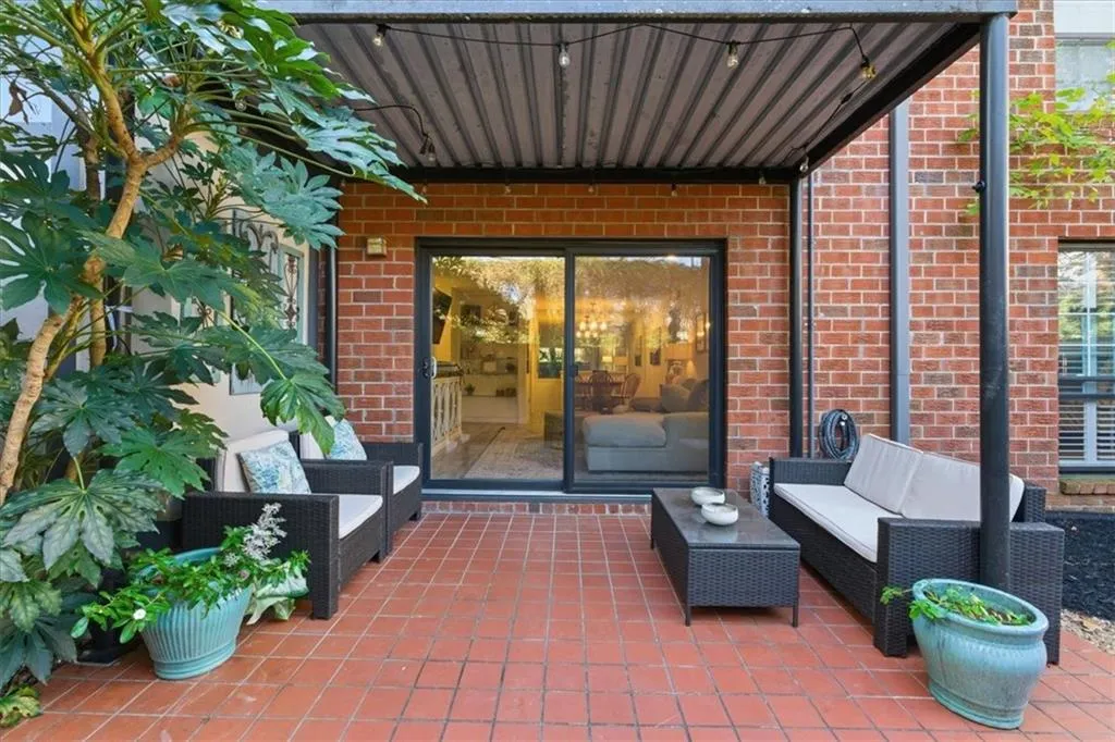 Entrance to property featuring outdoor lounge area, brick siding, and a patio