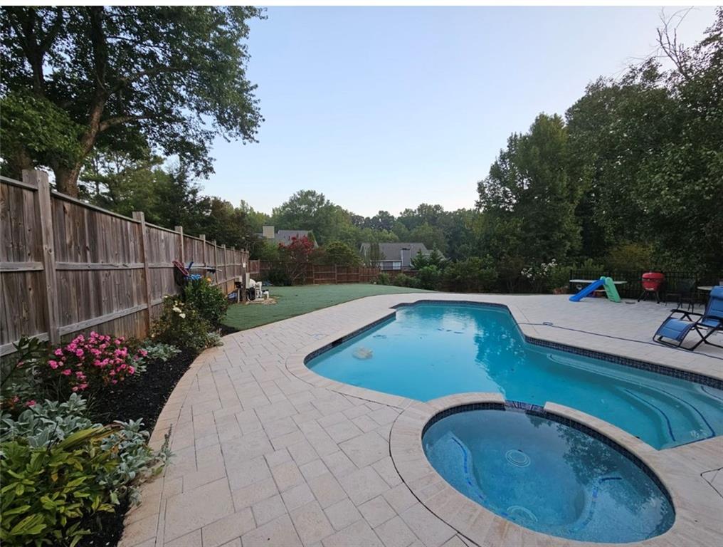 View of pool featuring a patio and an in ground hot tub