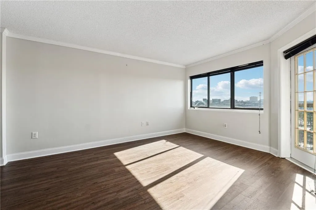 Spare room featuring a textured ceiling, dark hardwood / wood-style floors, and crown molding