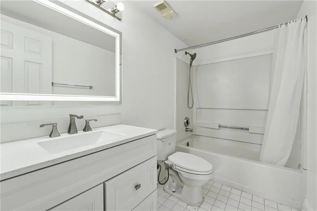 Full bathroom featuring tile patterned floors, shower / tub combo with curtain, vanity, and toilet