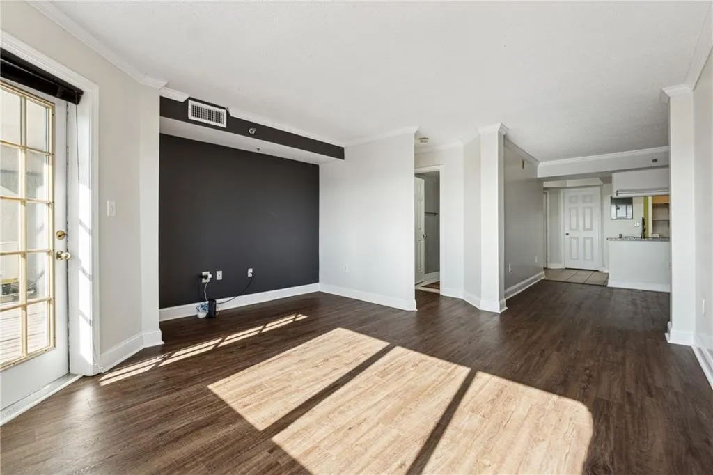 Spare room featuring crown molding and dark hardwood / wood-style floors