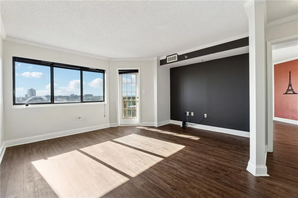 Unfurnished room with a textured ceiling, dark hardwood / wood-style flooring, and crown molding