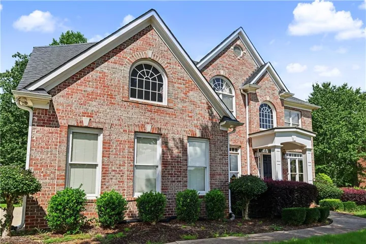 Brick exterior with multiple gables, arch-top windows, and a covered entry