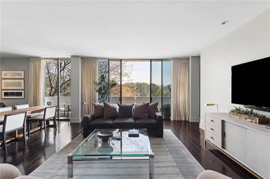 Living area featuring dark wood-style flooring and floor to ceiling windows