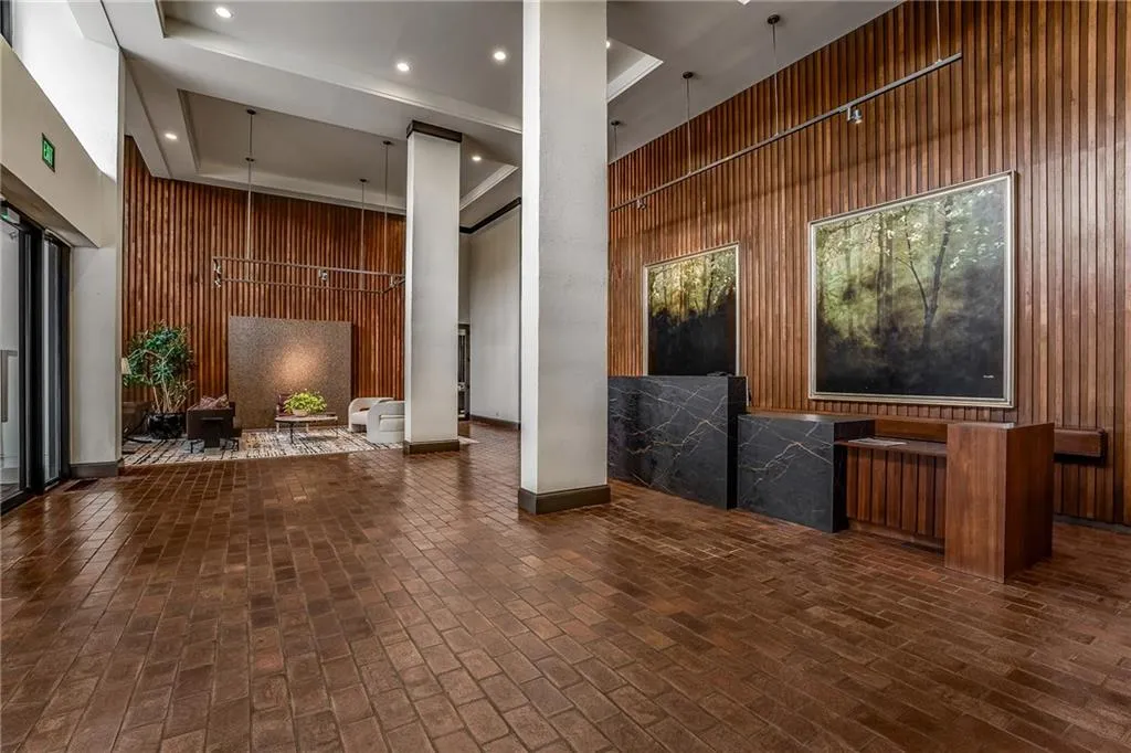 Lobby featuring wood walls, a high tray ceiling, and recessed lighting