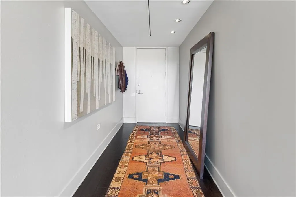 Corridor with dark wood-type flooring and recessed lighting