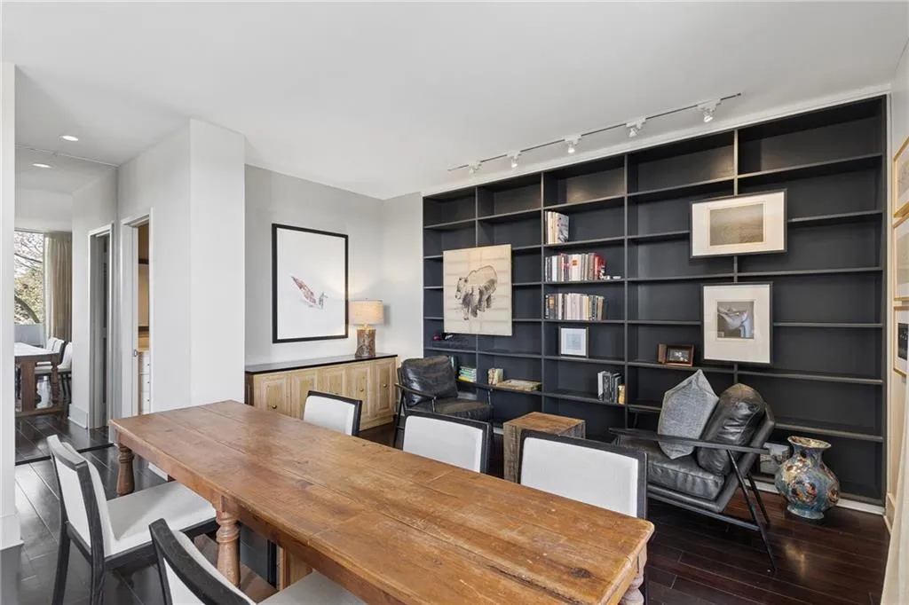 Office with dark wood-style floors, rail lighting, and built in features