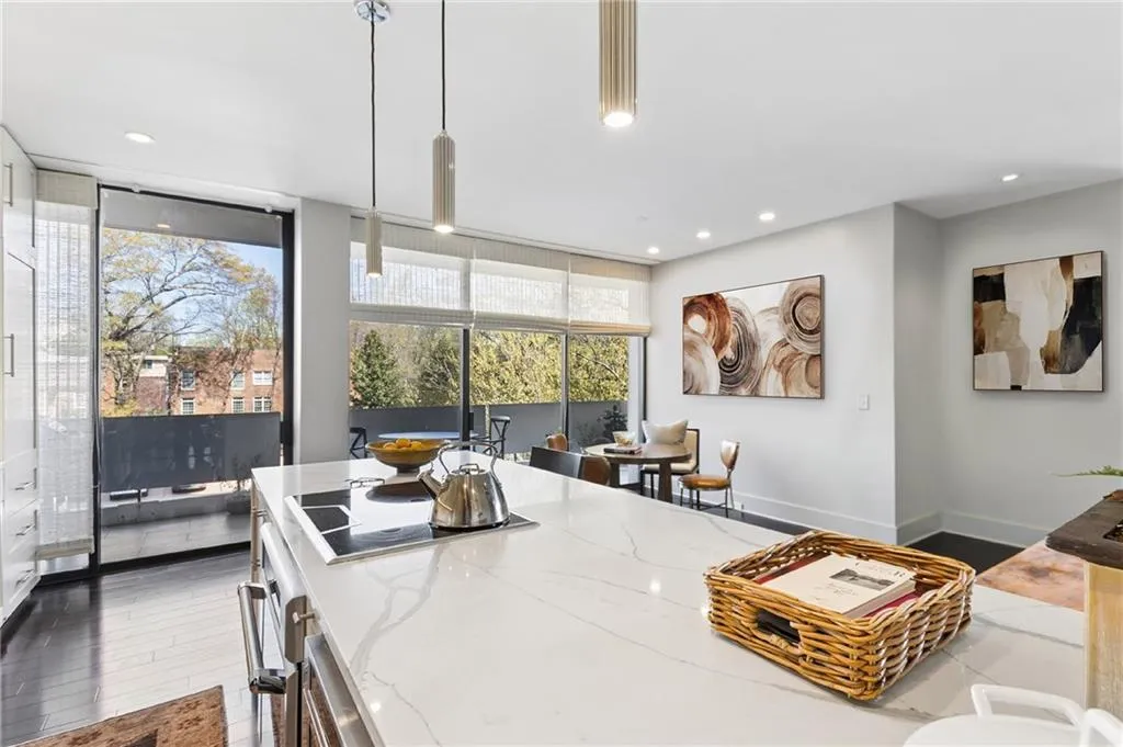 Kitchen featuring pendant lighting, dark wood-style flooring, light stone countertops, oven, and black electric cooktop