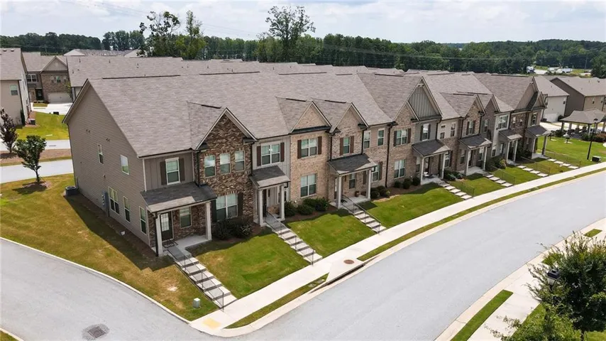 Townhome exterior with brick and siding facade, covered front entry, and gabled rooflines