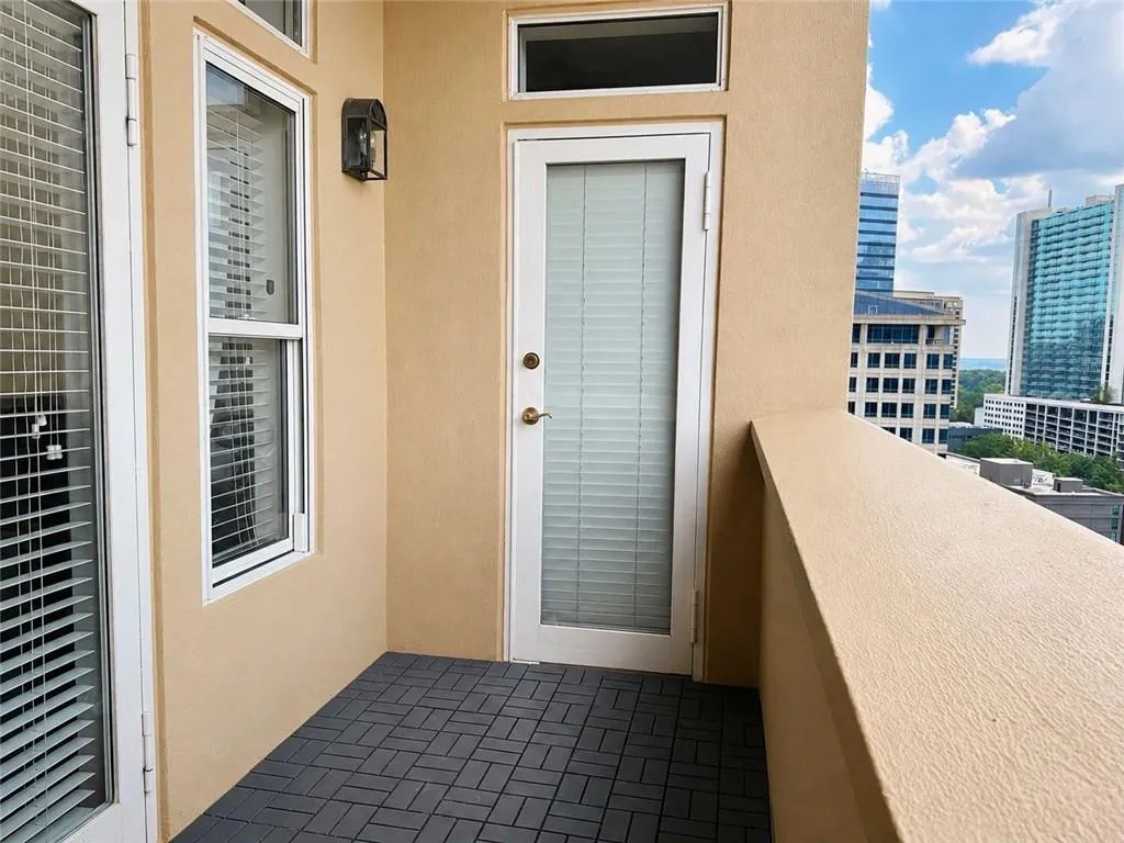 Balcony featuring patterned tile flooring and a stucco exterior