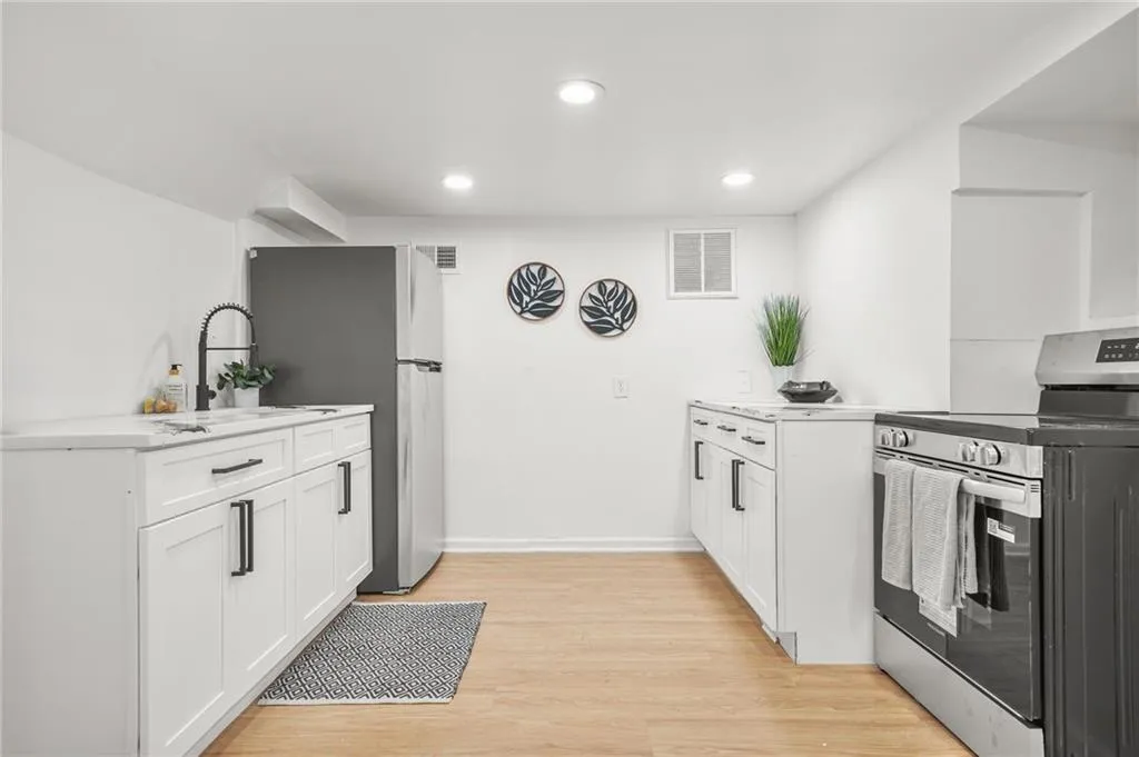 Kitchen featuring appliances with stainless steel finishes, light wood-style floors, white cabinets, recessed lighting, and light countertops