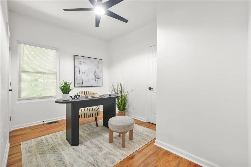 Office with light wood-style floors and ceiling fan
