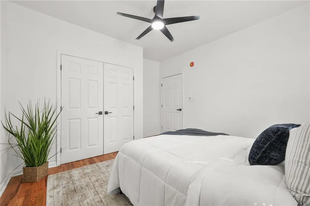 Bedroom featuring wood finished floors, a closet, and ceiling fan