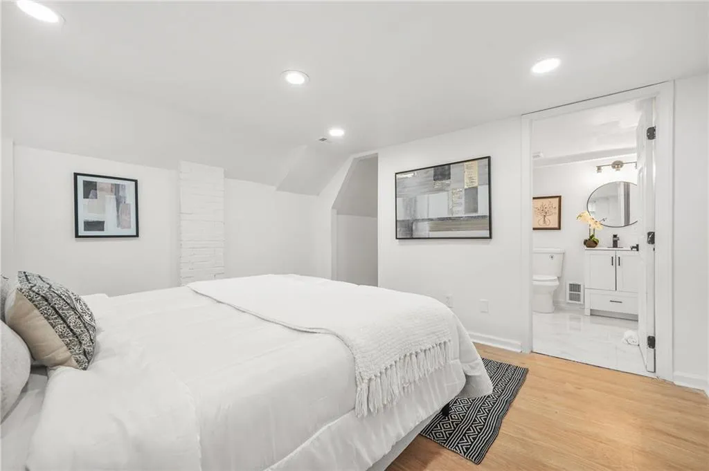 Bed - Lower LevelBedroom with recessed lighting, ensuite bathroom, wood finished floors, and vaulted ceiling.
