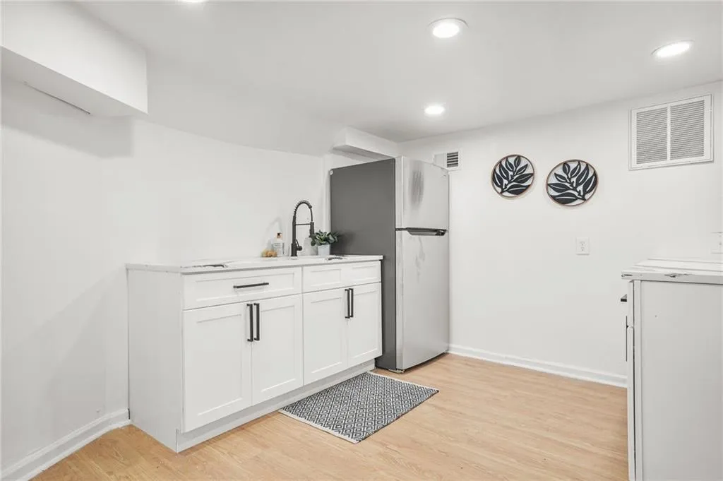 Bar area featuring freestanding refrigerator, light wood-style floors, recessed lighting, and washer / dryer