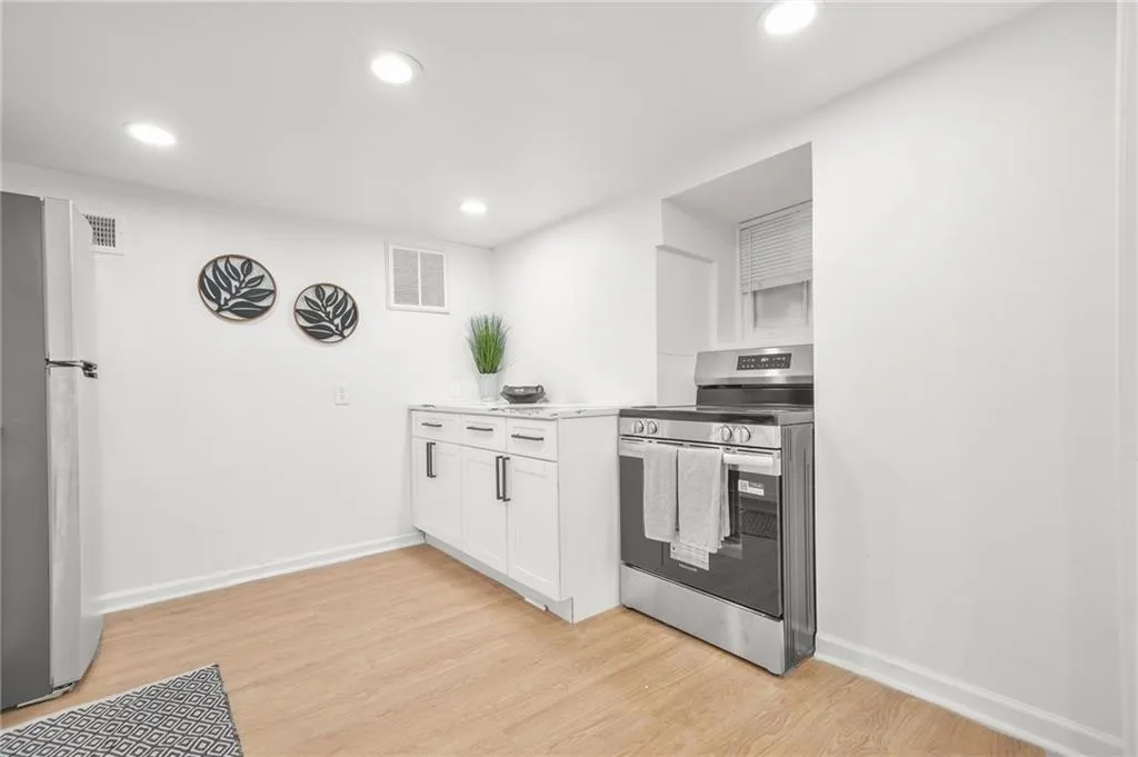 Kitchen featuring stainless steel electric range oven, freestanding refrigerator, white cabinets, recessed lighting, and light wood-type flooring