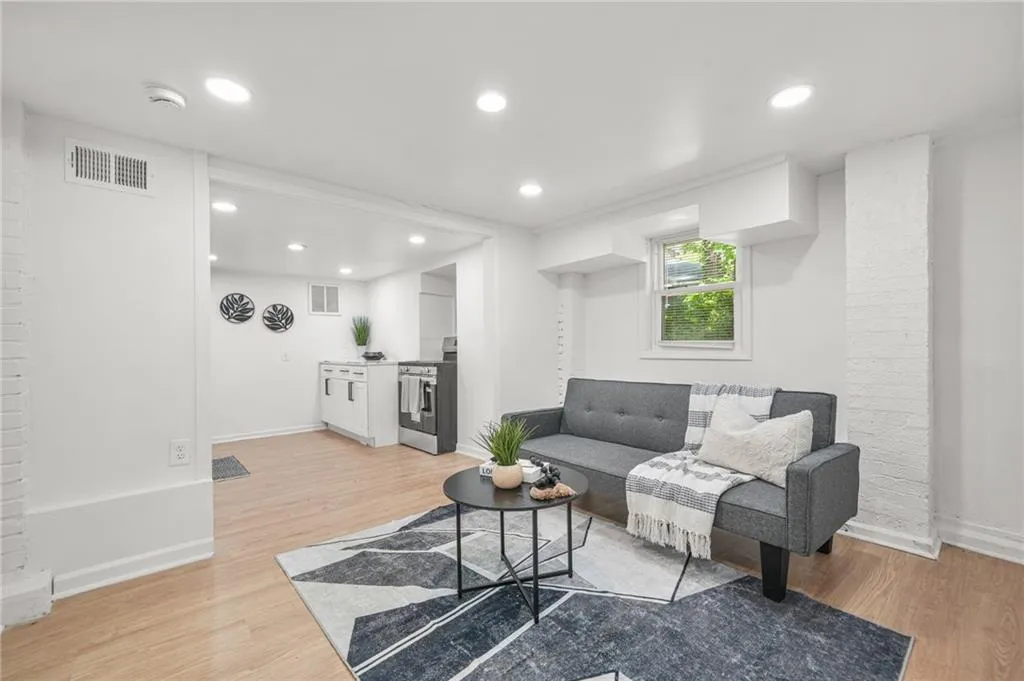 Living area with light wood finished floors and recessed lighting