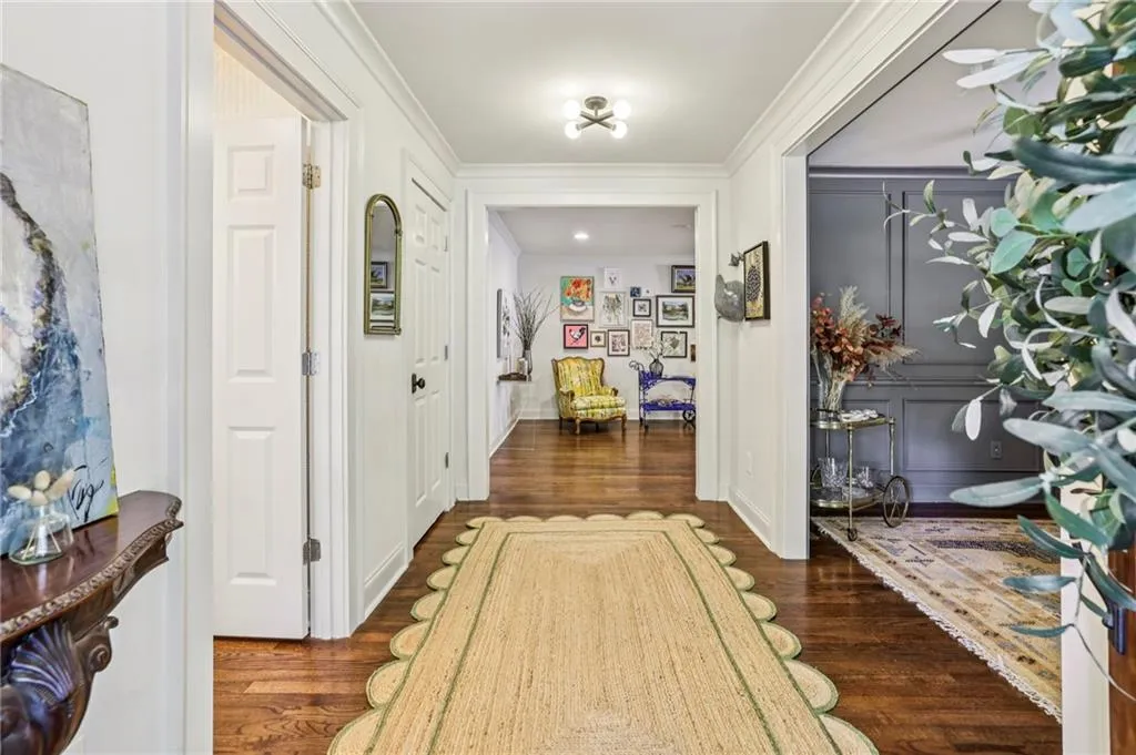 Corridor featuring crown molding and dark wood-style flooring
