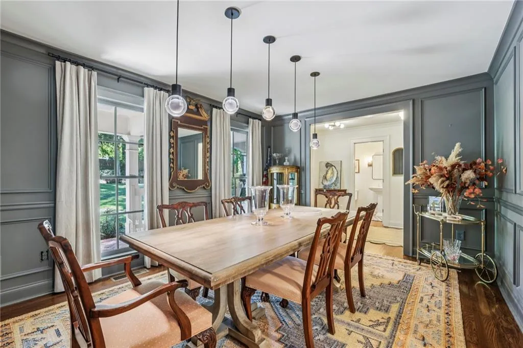 Dining room featuring a decorative wall, wood finished floors, and crown molding