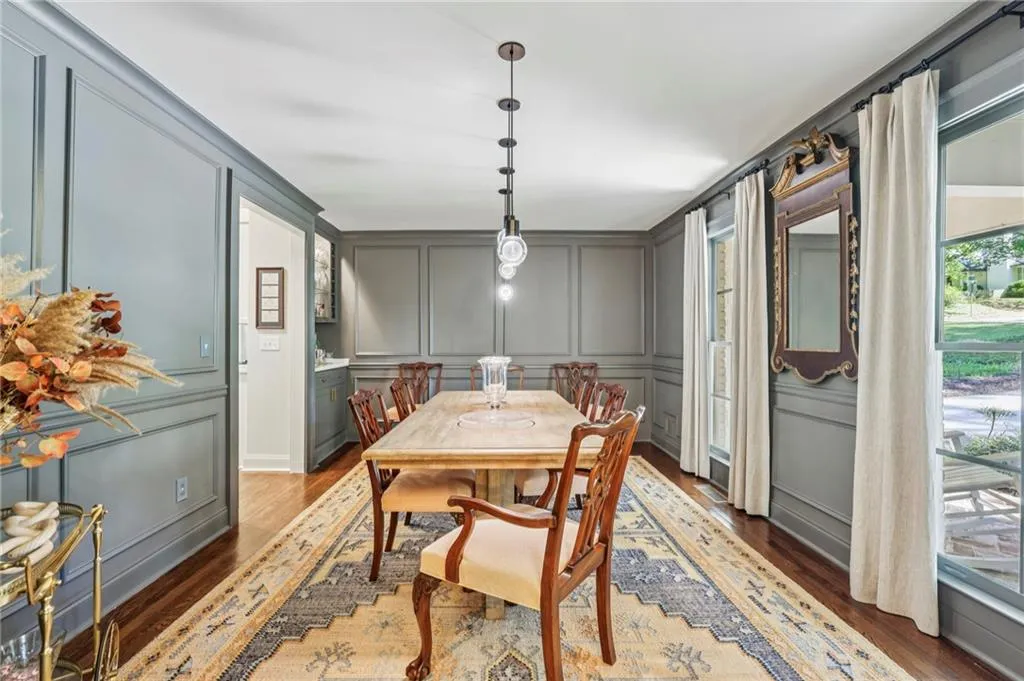Dining area with a decorative wall and dark wood-style floors