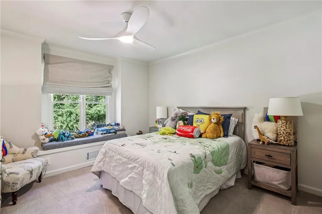 Carpeted bedroom with ornamental molding and ceiling fan