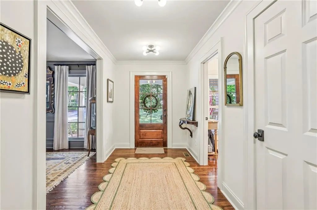Entrance foyer with dark wood finished floors and ornamental molding