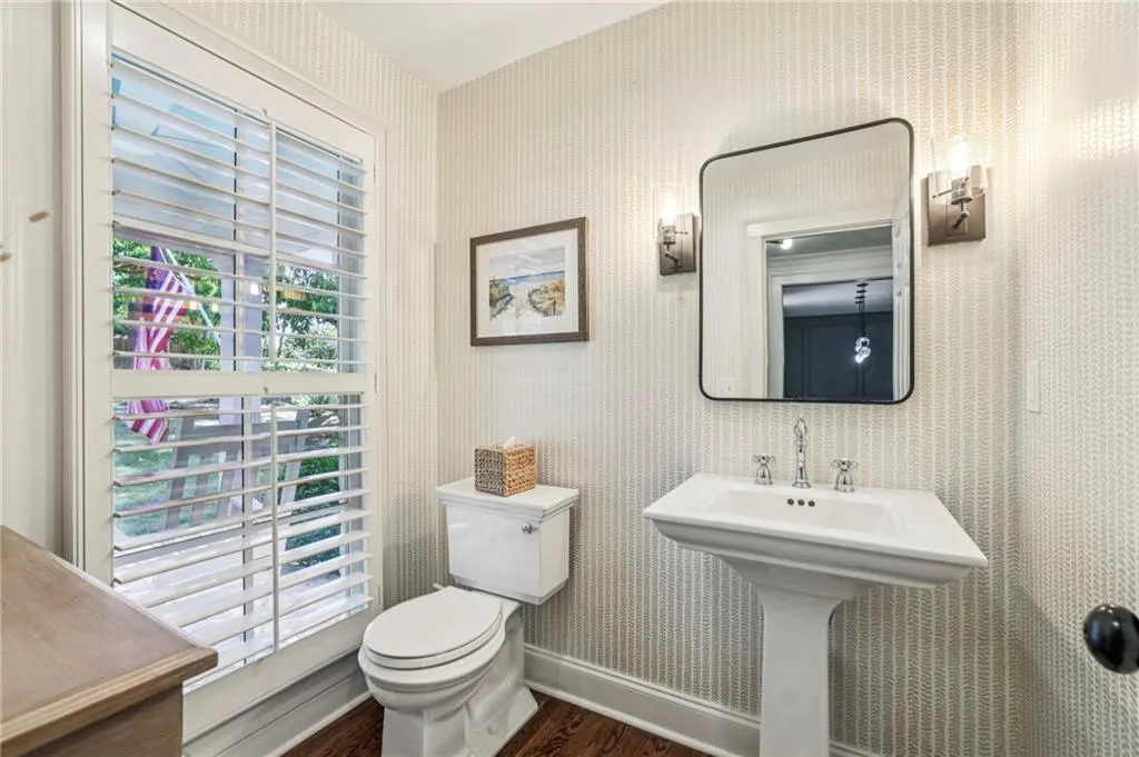 Bathroom with wallpapered walls and wood finished floors